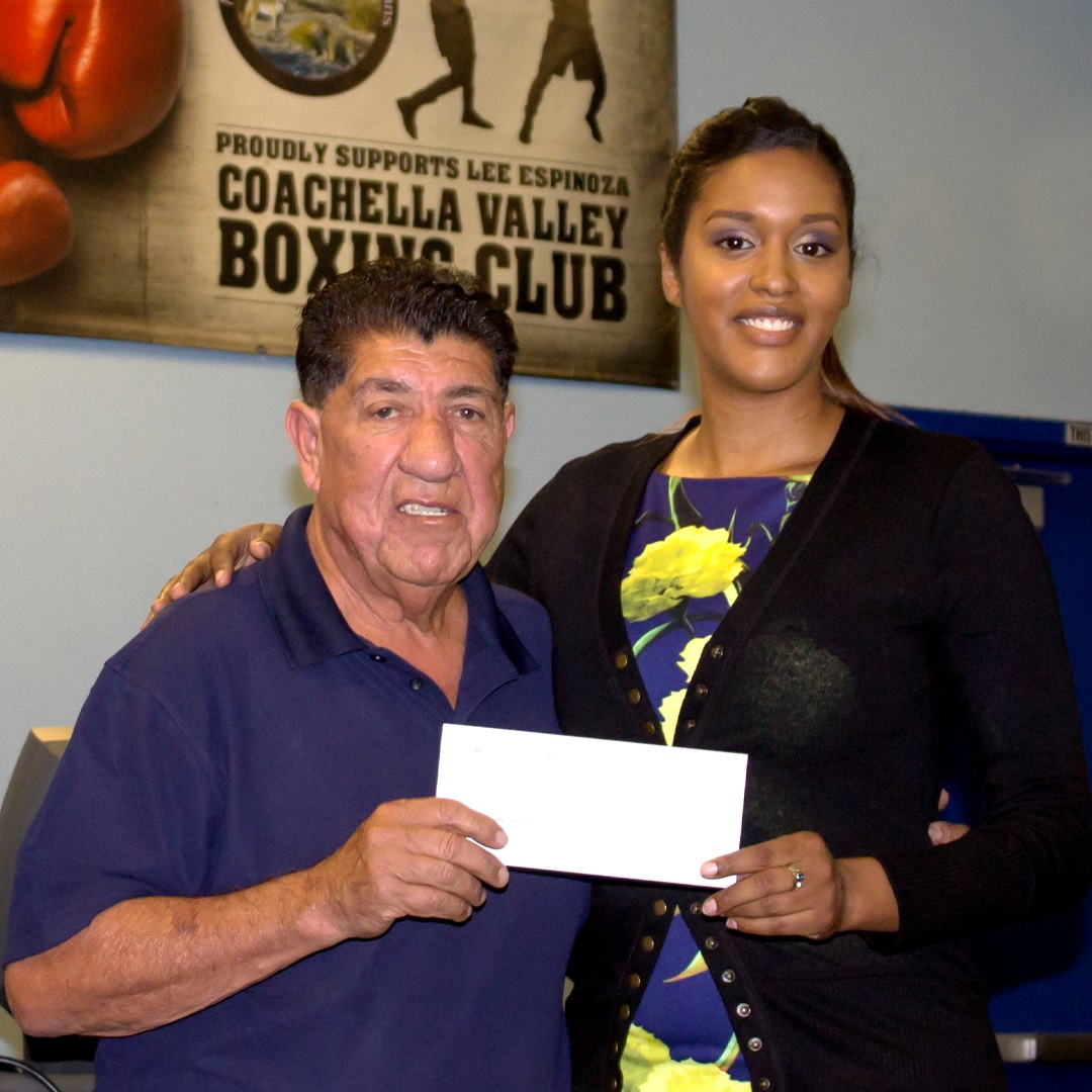 woman and a man holding a check