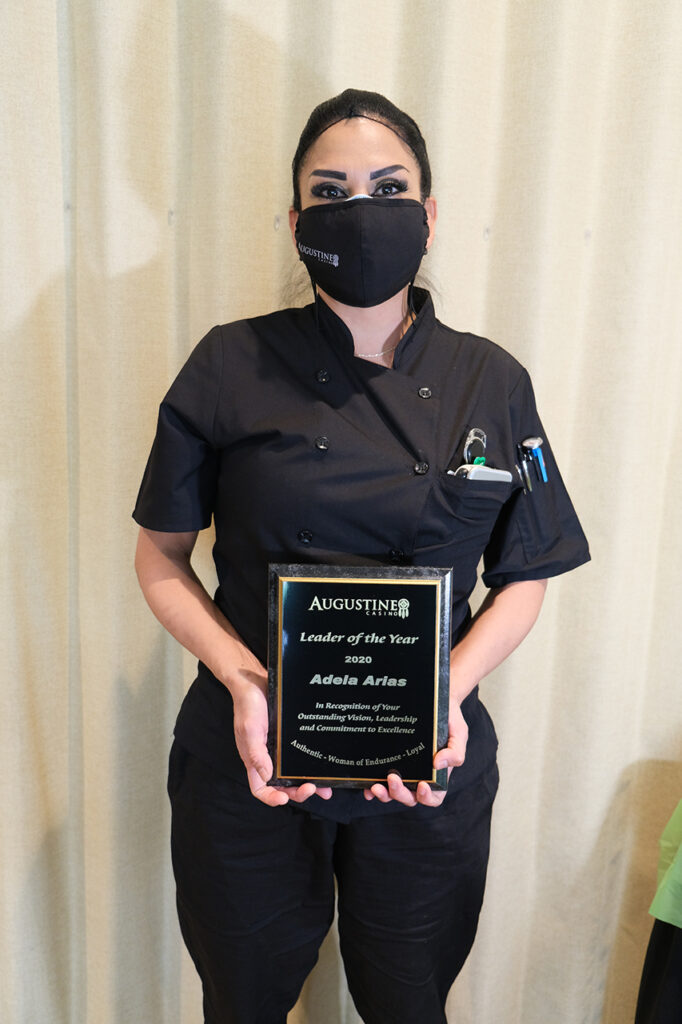 woman with a hairnet holding an award