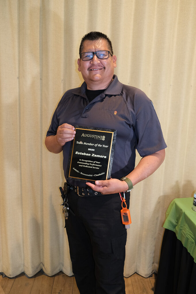 bespectacled man holding an award