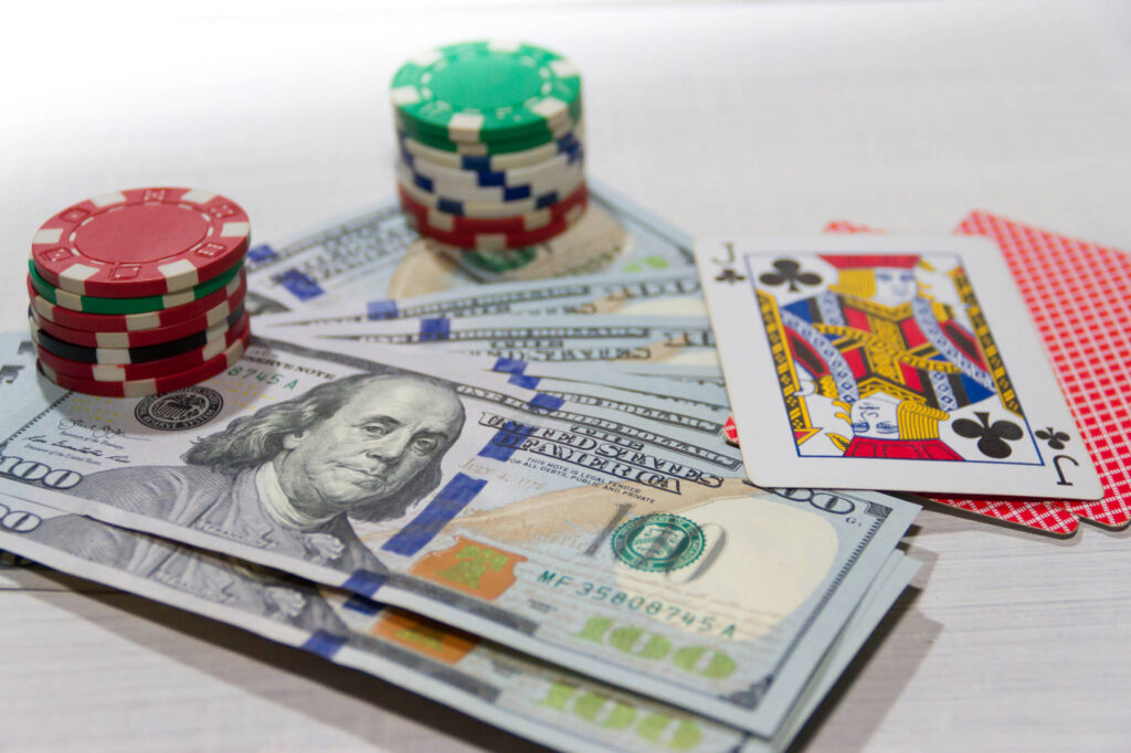 Playing Cards, Money, and poker chips on a table.