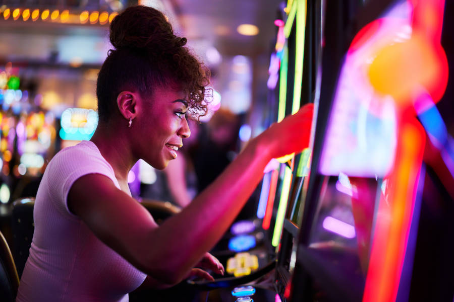 Happy women playing a slot machine at a Casino.